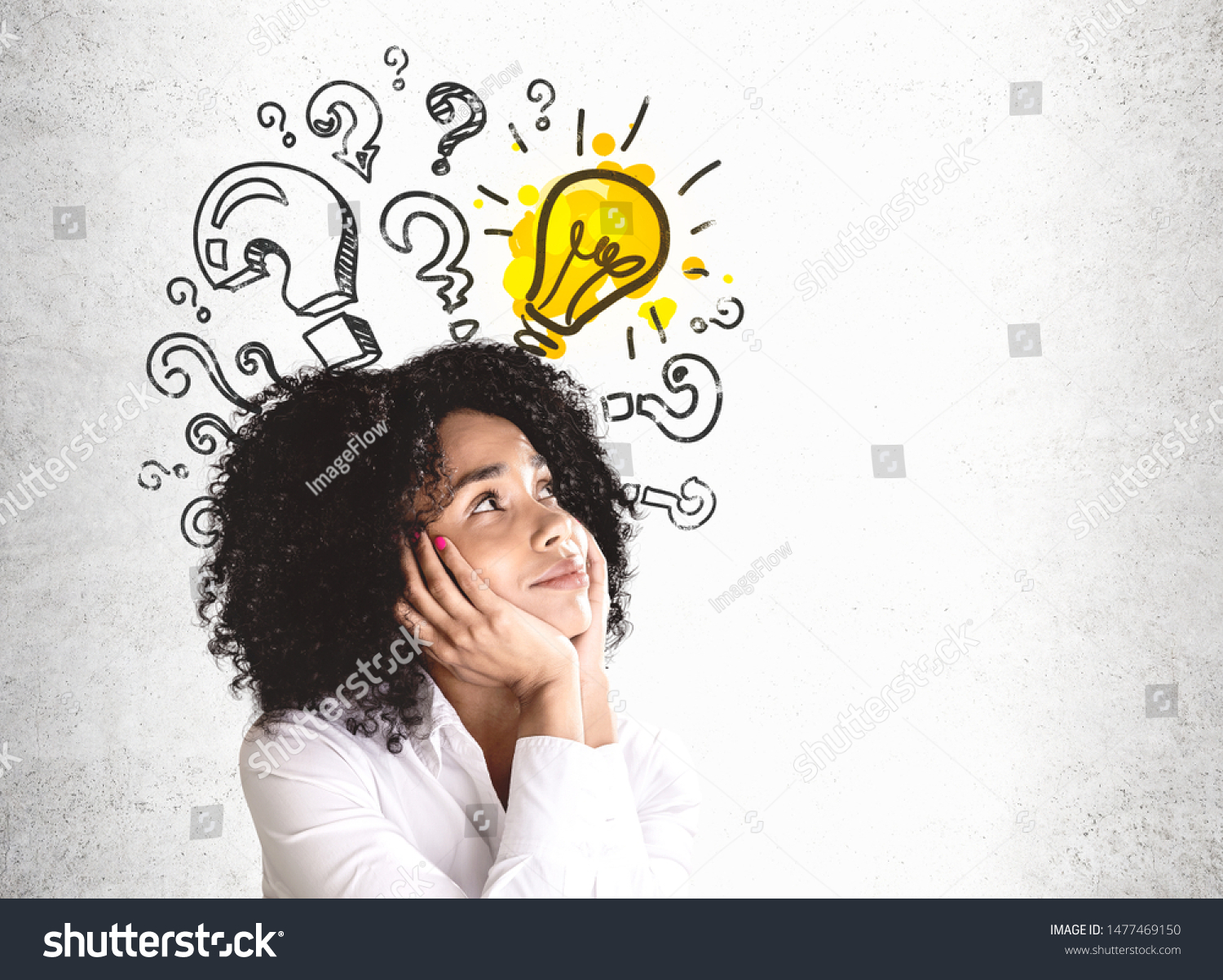 Smiling young African American woman in white shirt looking at question marks and lightbulb drawn on concrete wall. Concept of good idea. Mock up #1477469150