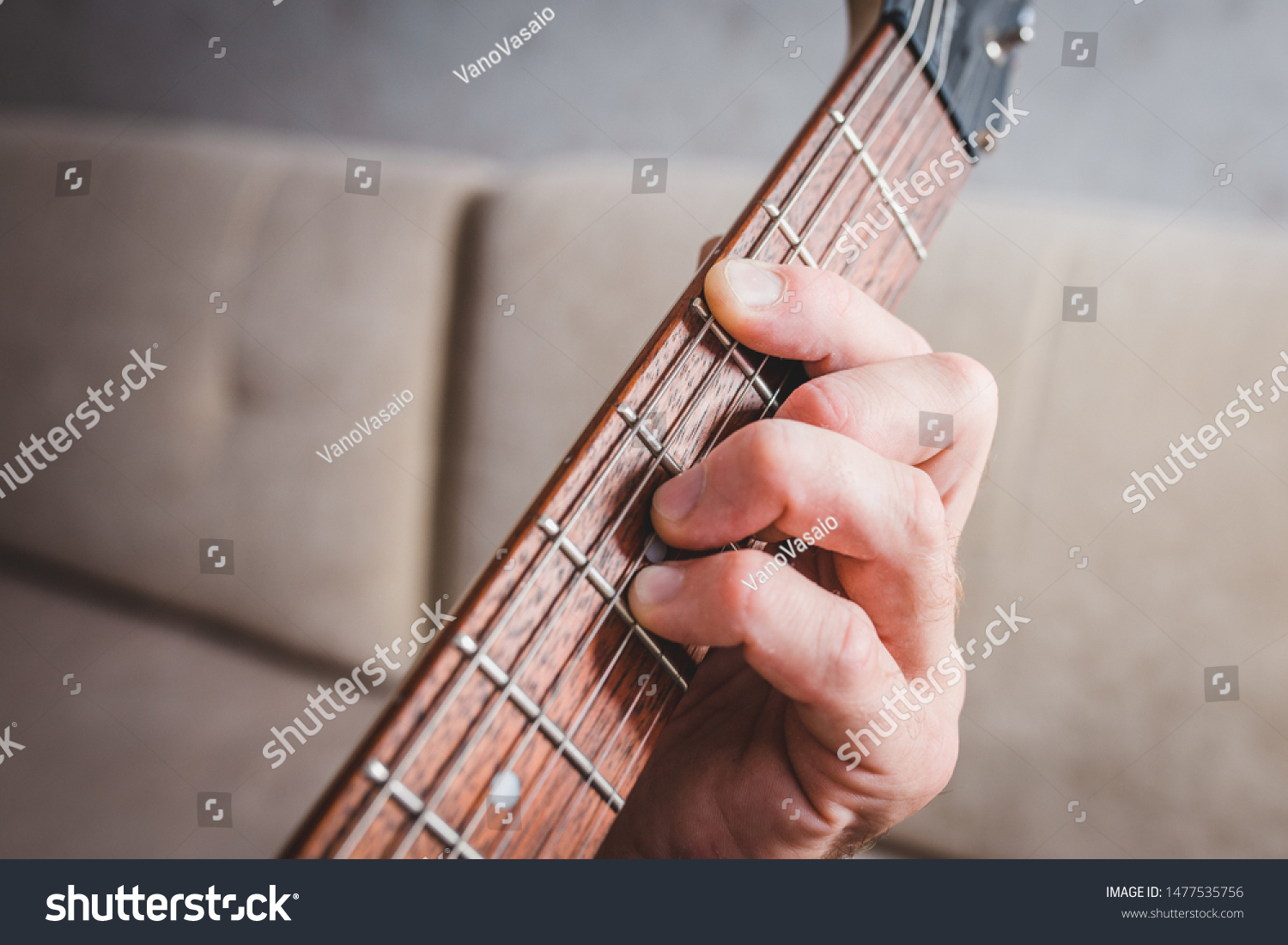 Cm chord - close-up male Caucasian hand takes a chord on a 6 string guitar #1477535756