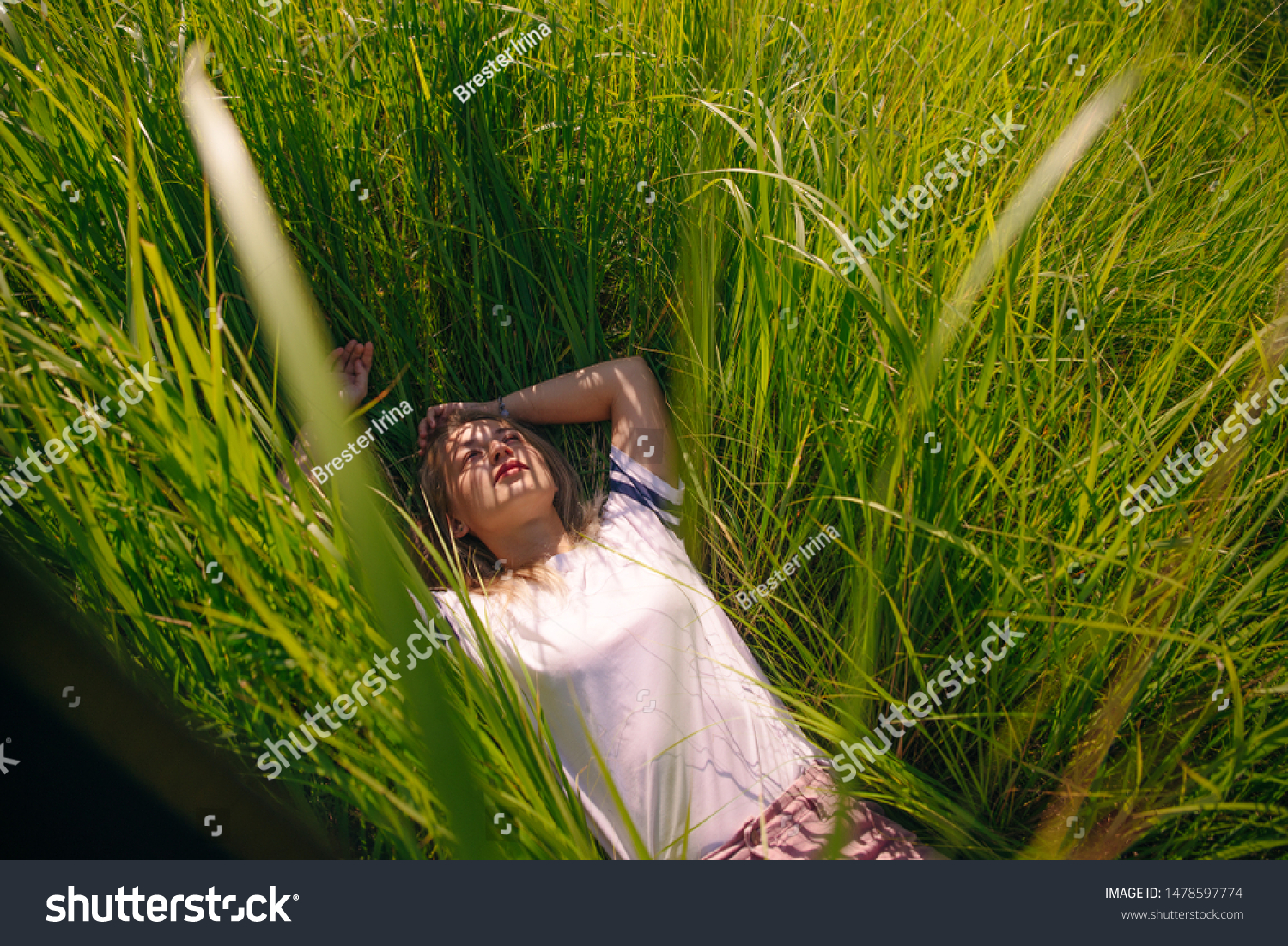 T-shirt design concept - beautiful girl lies in grass in blank white t-shirt in grass #1478597774
