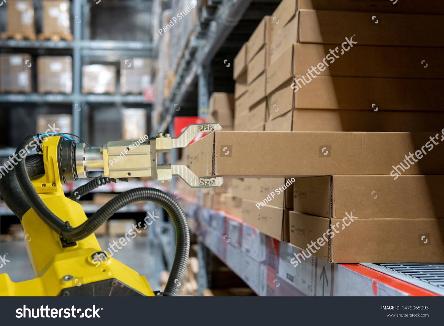 yellow robotic arm carry cardboard box in warehouse #1479065993