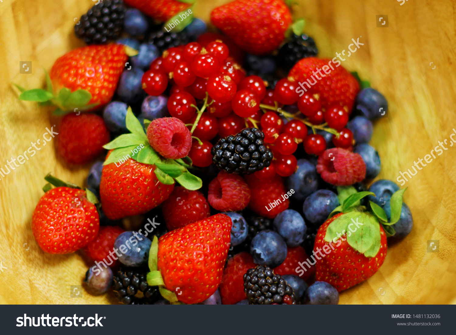 fresh berries fruit in wooden bowl includes strawberry, raspberry,blue berry,black berry etc. #1481132036