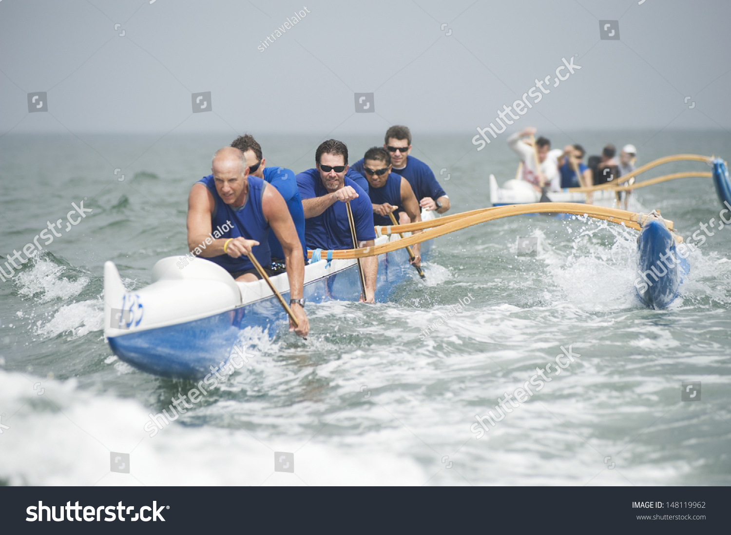 Crew of a racing outrigger canoe on water #148119962