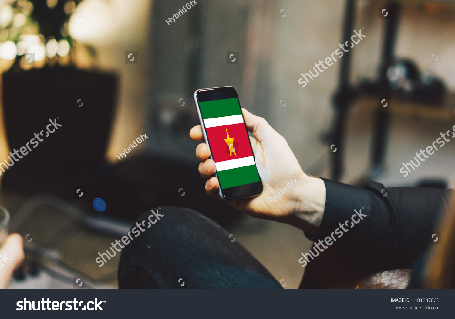 Man holding Smartphone with Flag of Suriname. Suriname Flag on Mobile Screen. #1481247803