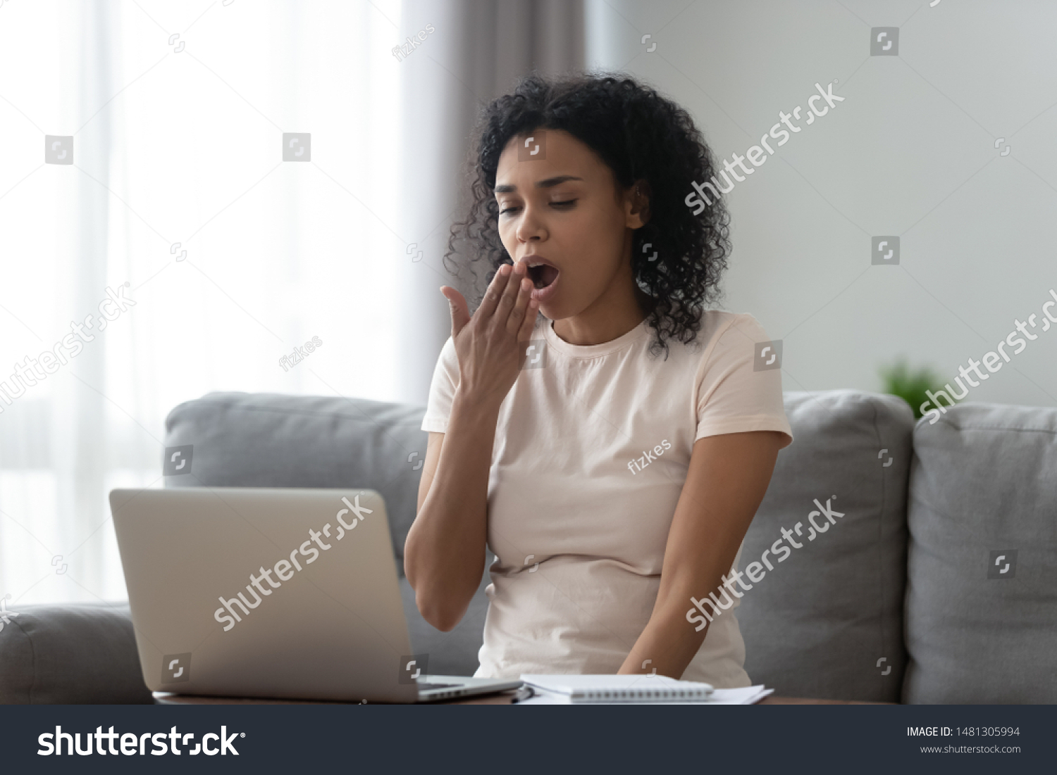 Tired african American young woman sit on sofa yawn feel fatigue working long on laptop, exhausted black millennial girl sigh having sleep deprivation, overwhelmed with computer studying at home #1481305994