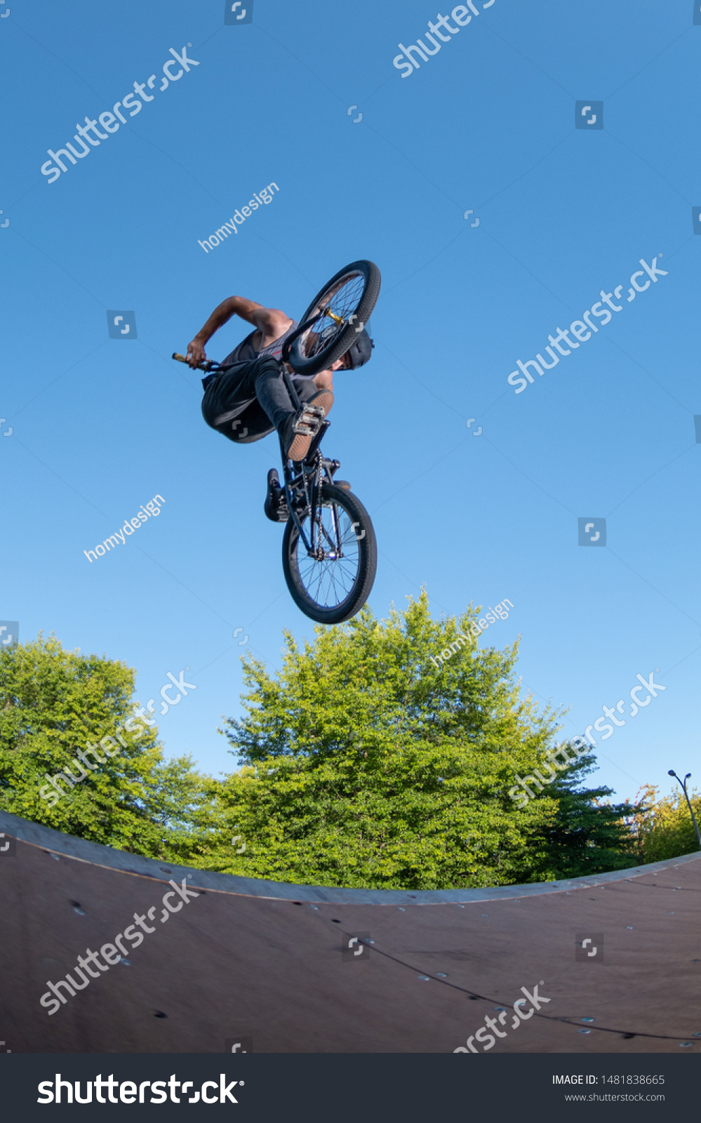Biker jump high from jump box ramp performing big air trick. #1481838665