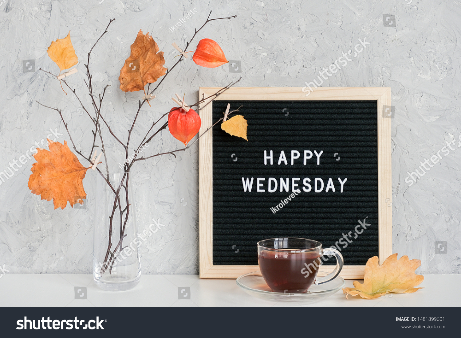 Happy Wednesday text on black letter board and bouquet of branches with yellow leaves on clothespins in vase on table Template for postcard, greeting card Concept Hello autumn Wednesday. #1481899601