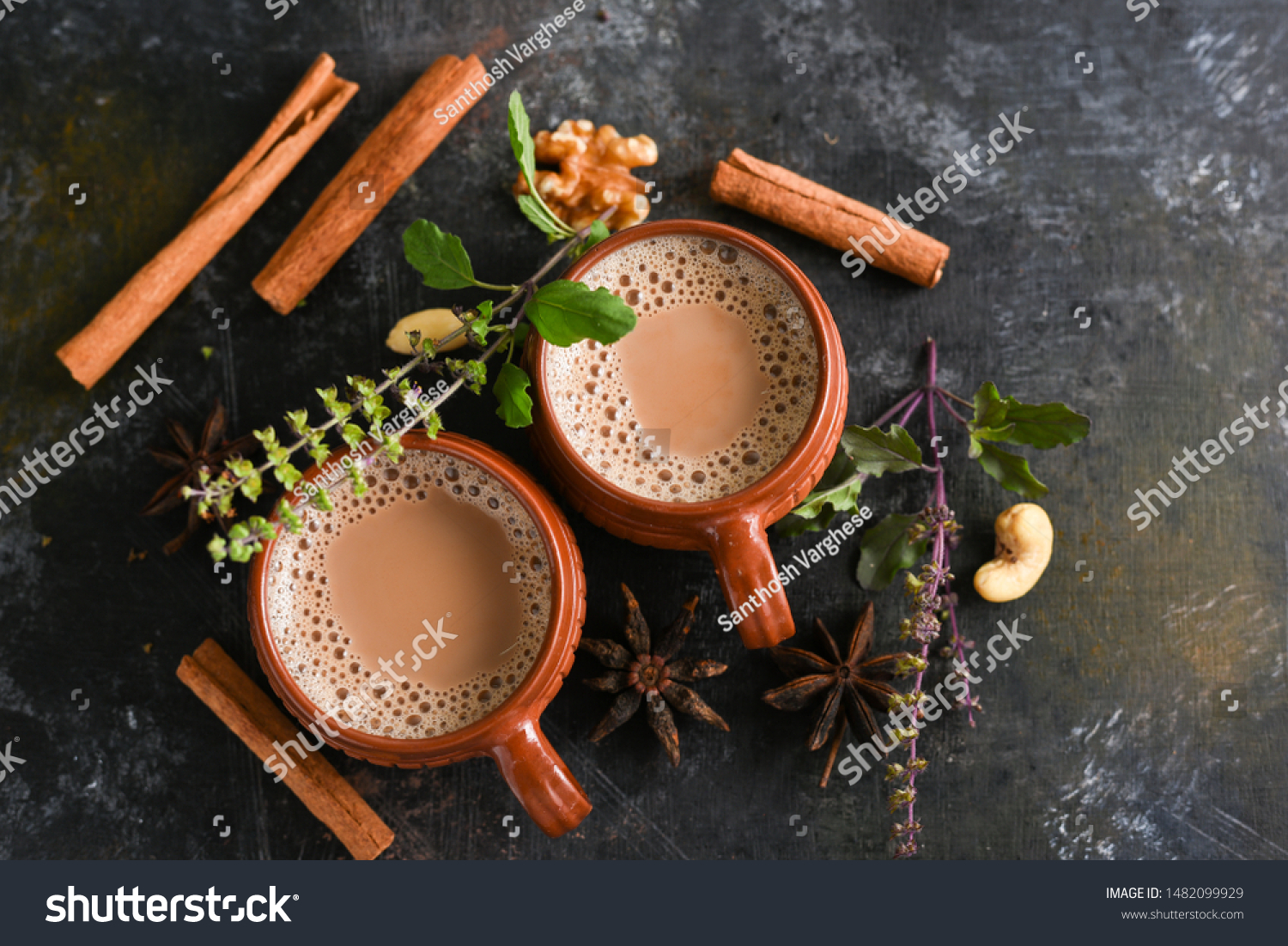 Top view of Indian Masala Chai or traditional beverage with tea, milk and spices Kerala India. Two cups of organic ayurvedic or herbal drink India, good in winter for immunity boosting. #1482099929