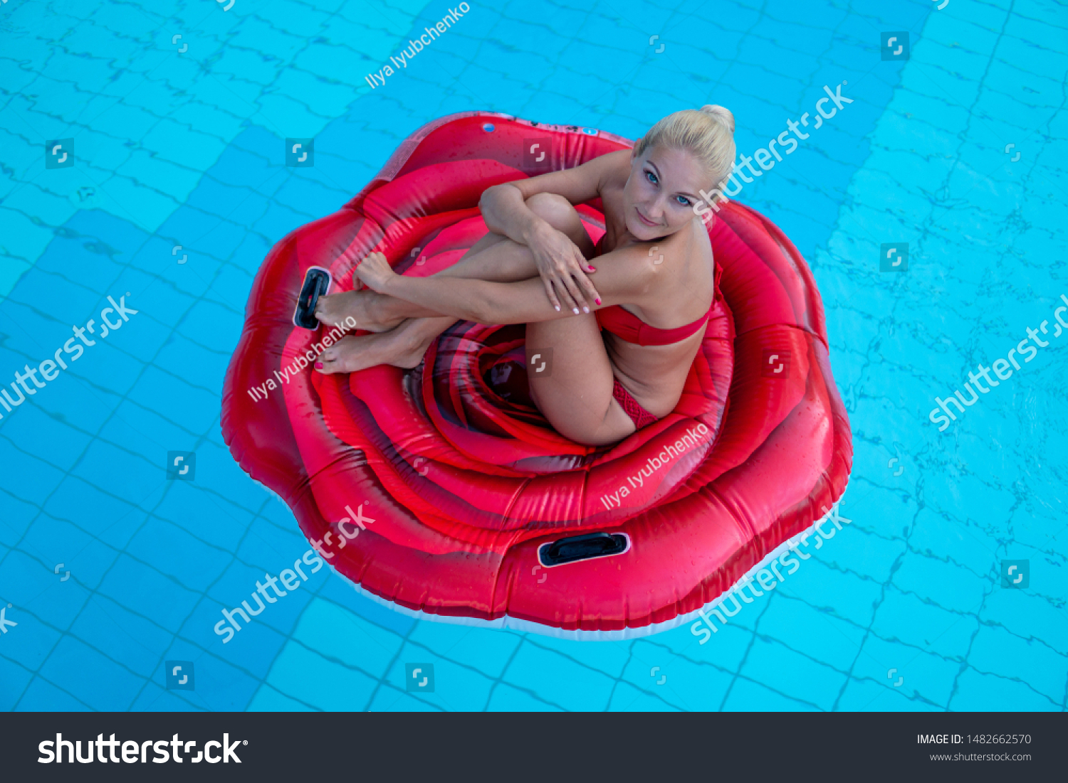 Gorgeous gorgeous Lady in red bathing suits on an inflatable mattress red rose floating in the pool, elegant hotels, summer vacation, happiness, travel, smile, joy, top view #1482662570