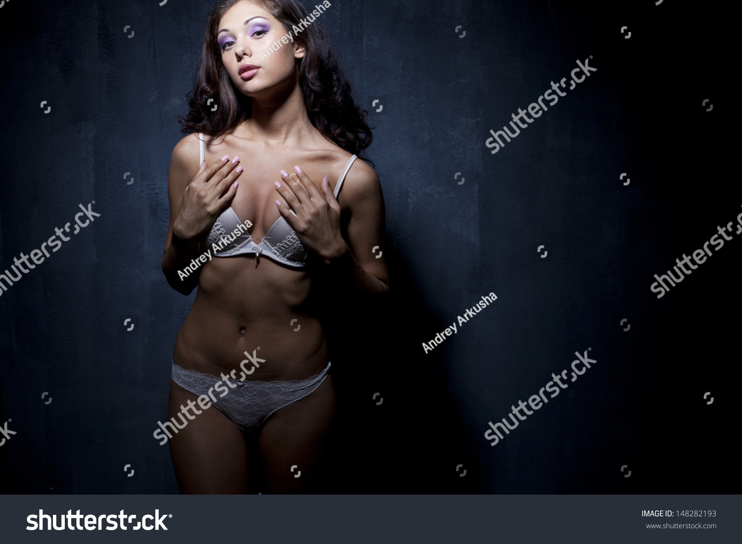 Portrait of sexy woman in white underwear on a dark wall #148282193