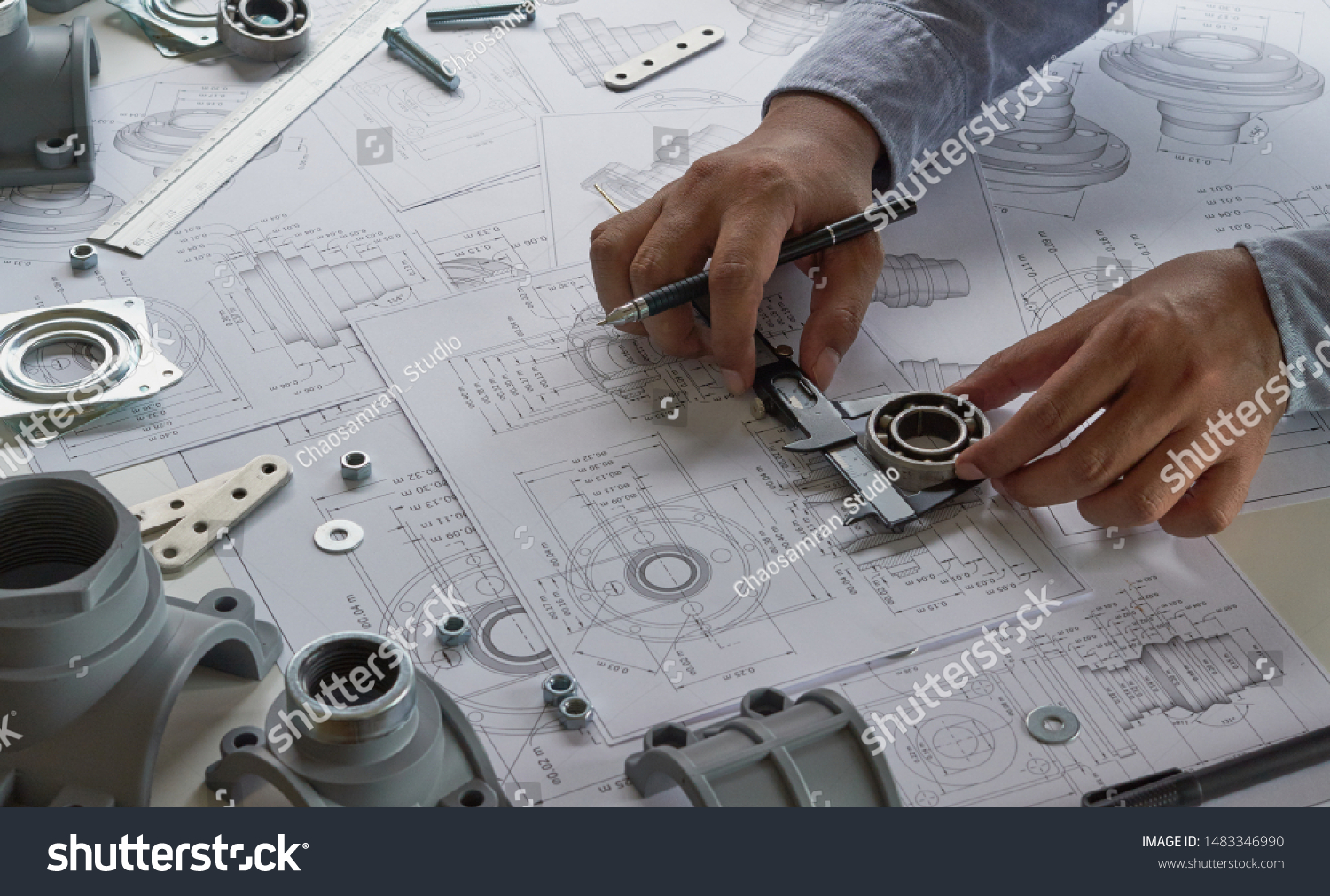 Engineer technician designing drawings mechanical parts engineering Engine
manufacturing factory Industry Industrial work project blueprints measuring bearings caliper tools #1483346990