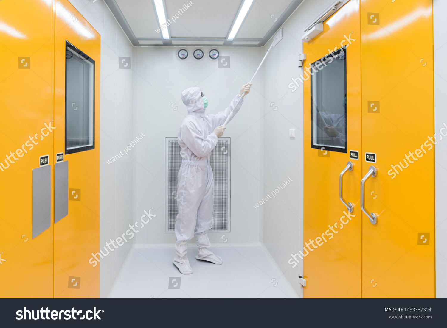 A scientist in sterile coverall gown using Cleaning tool for cleaning laboratory. Cleanroom facility. #1483387394