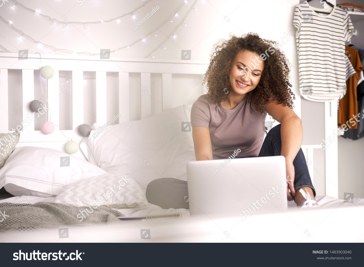 Teenage girl using a laptop in her bedroom  #1483903040