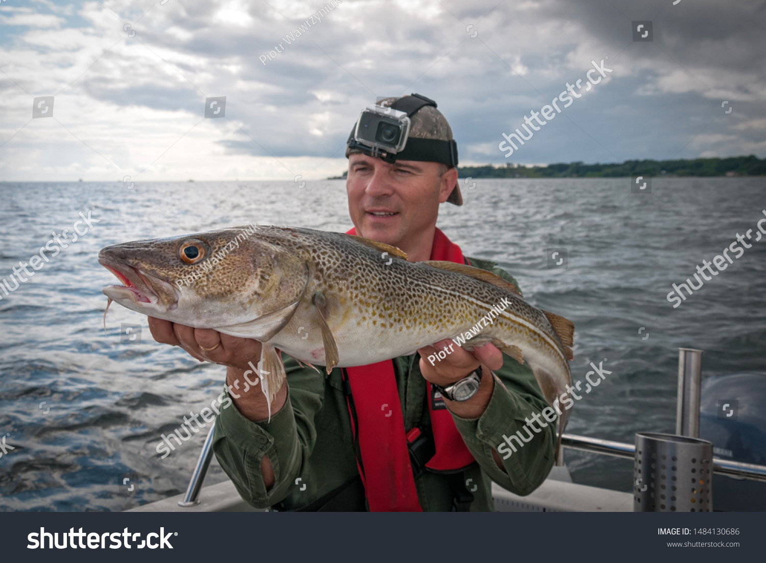 Happy angler with cod fishing trophy #1484130686