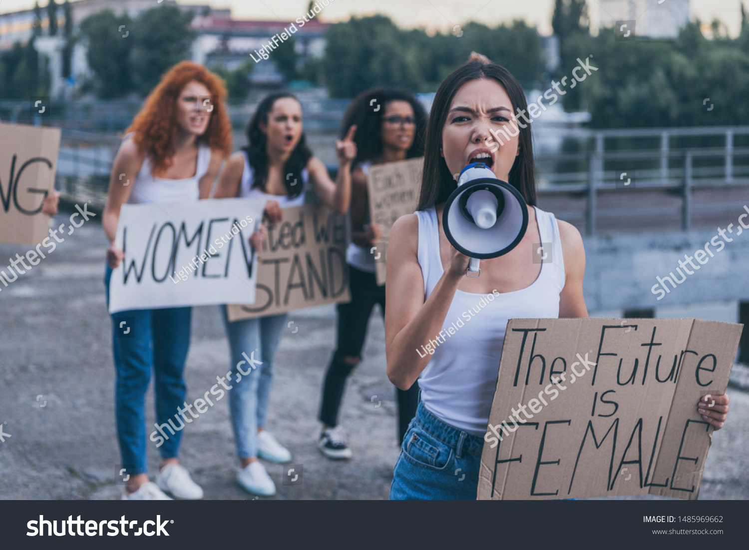 selective focus of emotional girl holding placard with the future is female letters and screaming in megaphone outside  #1485969662
