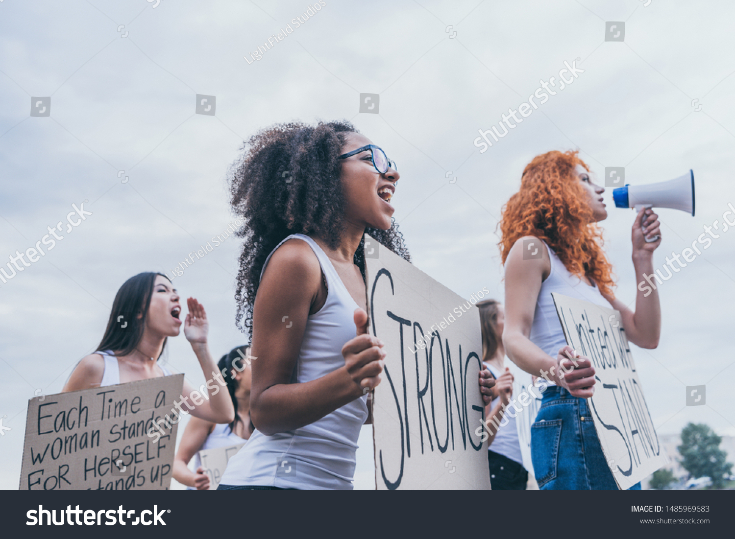selective focus of african american girl holding placard with strong letters near women  #1485969683