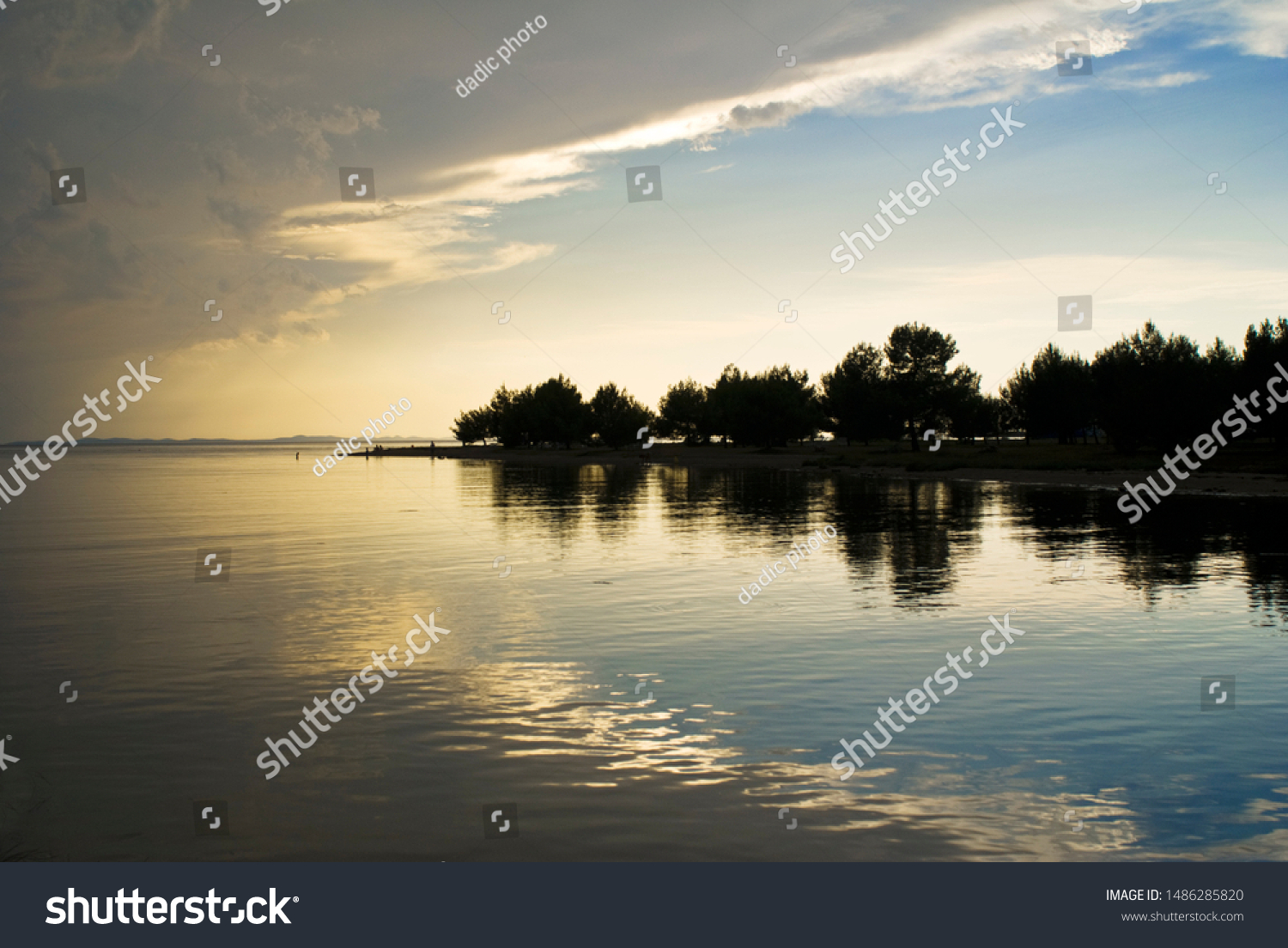 sunset on the lake and silhouette of the forest #1486285820