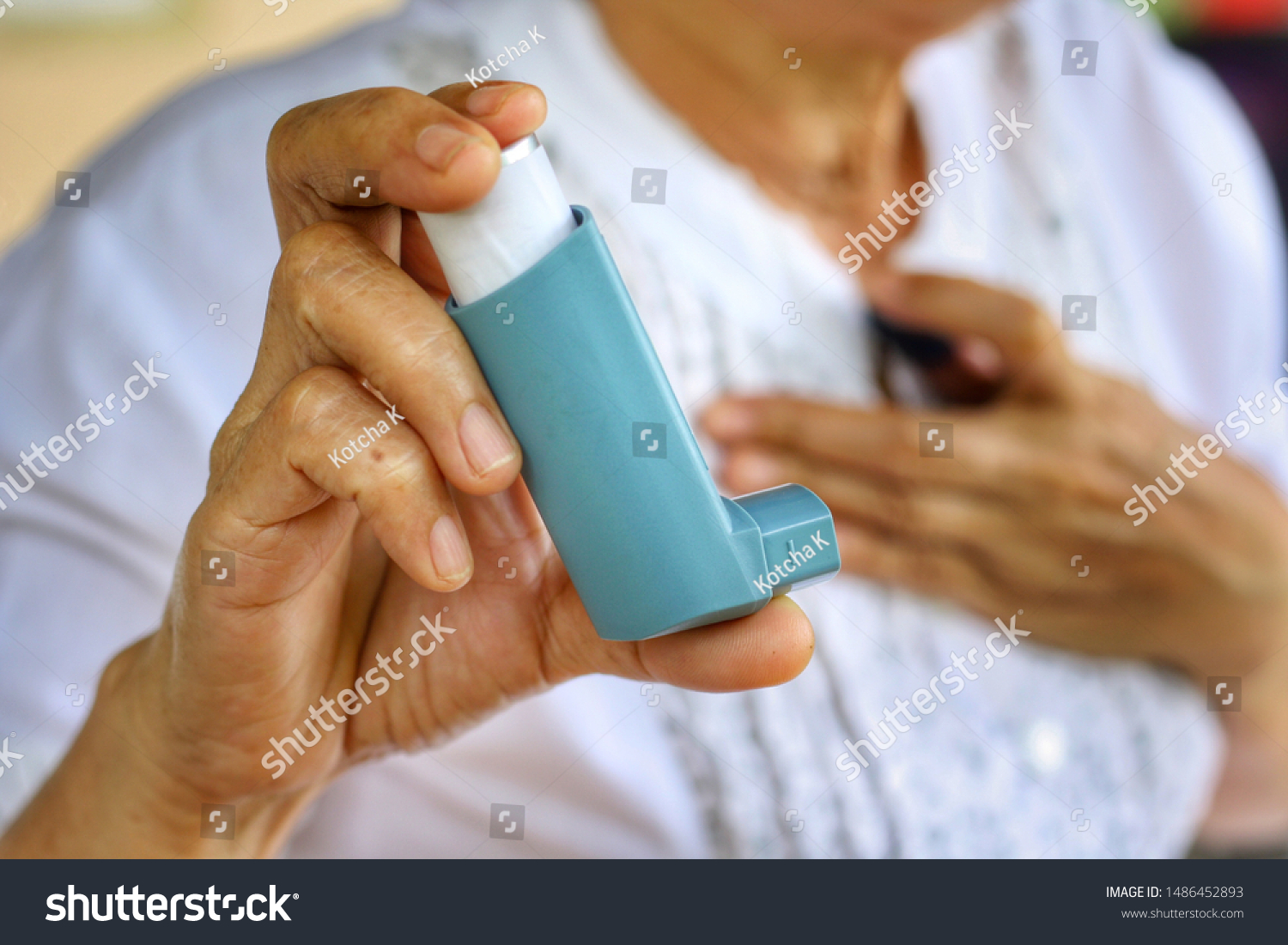 Elderly Female's hand use inhaler while difficulty of breathing.Medication for relief bronchospasm or Dyspnea from asthma attack or allergy,that's an emergency condition.Healthcare and medical concept #1486452893