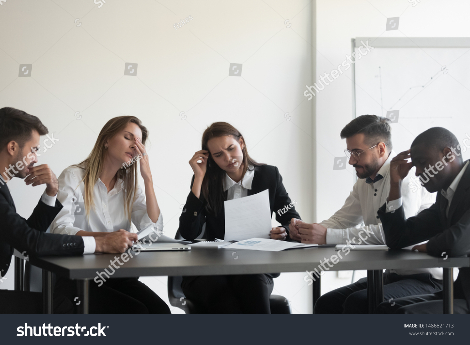 Frustrated upset multiracial business team people sad with bad work result in report disappointed in corporate bankruptcy failure crisis worried of paperwork problem sit at table at office meeting #1486821713