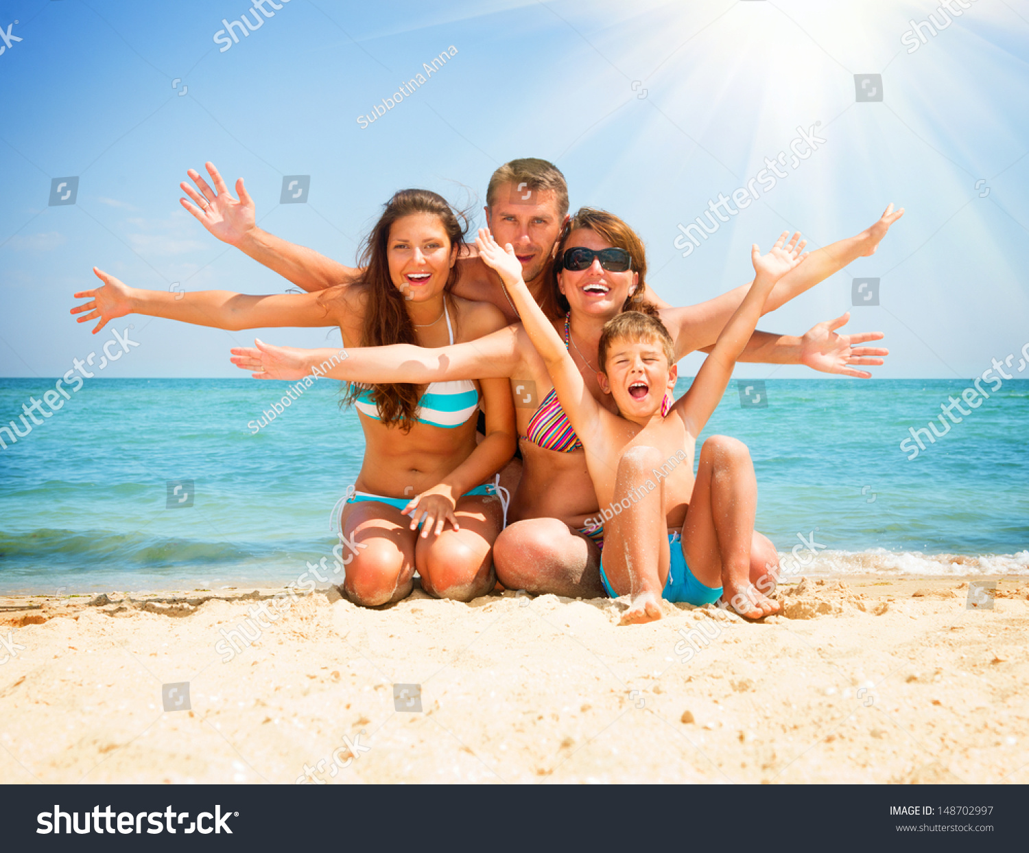 Happy Family Having Fun at the Beach. Joyful Family. Vacation and Travel concept. Summer Holidays. Parents with Children enjoying a holiday at the sea #148702997