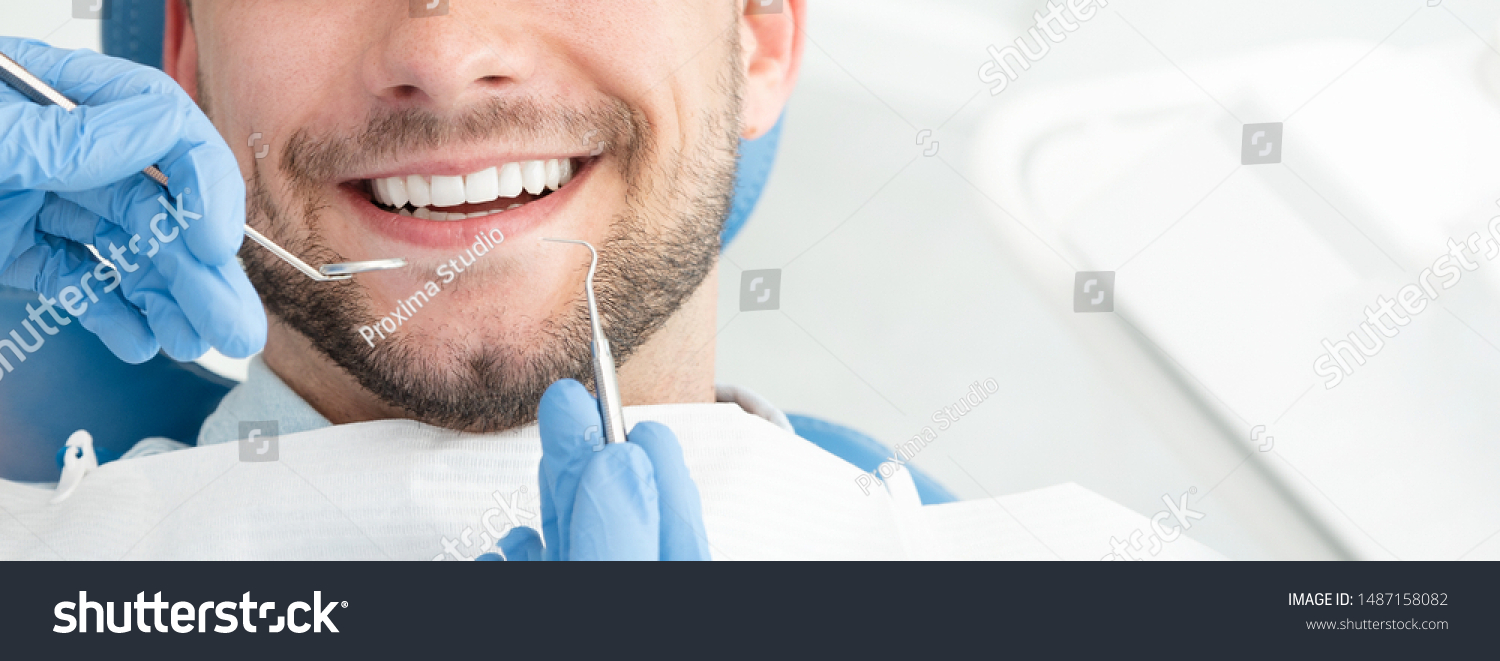 Young man at the dentist. Dental care, taking care of teeth. Picture with copy space for background. #1487158082