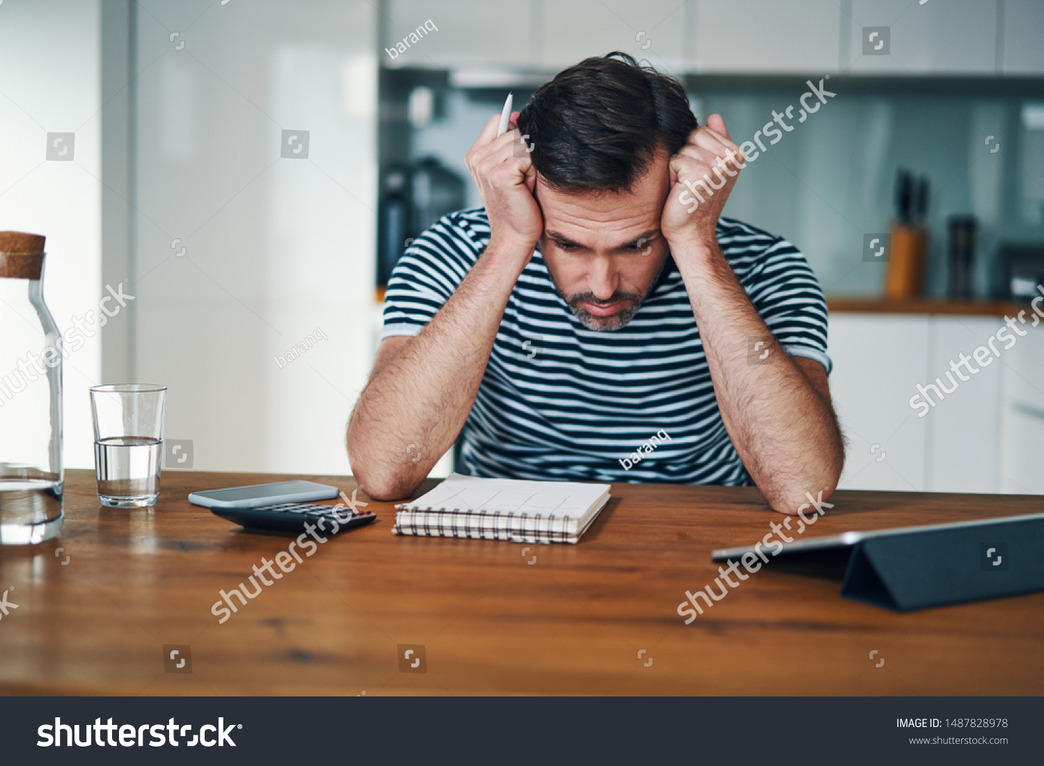 Sad man looking at notebook with home budget and stressing over money #1487828978