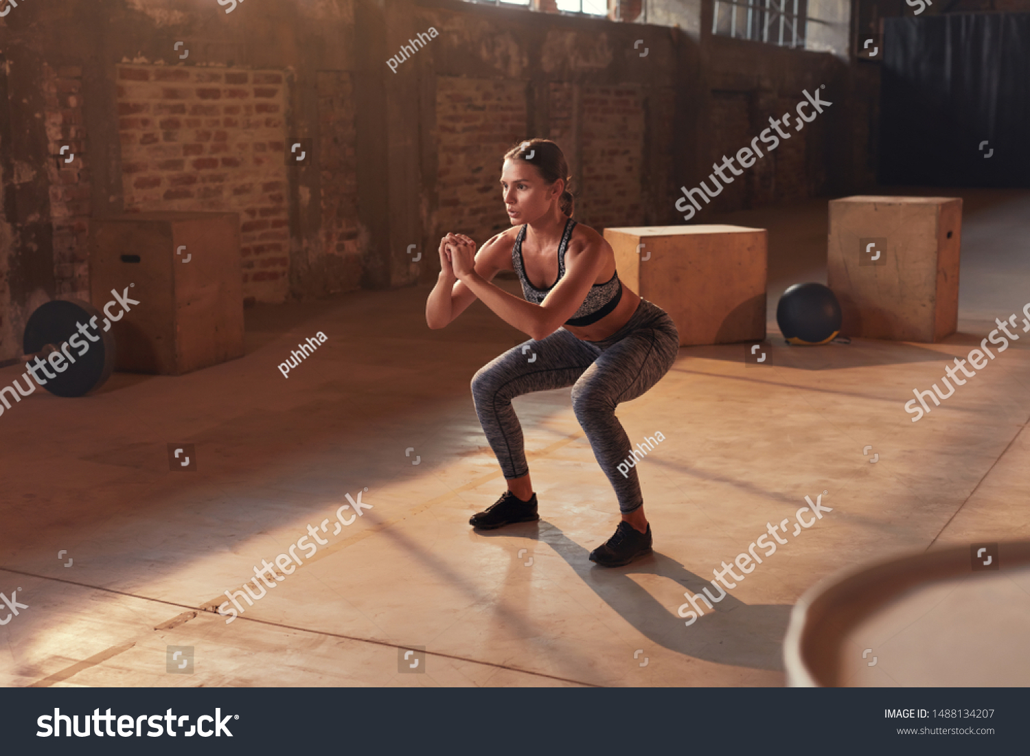 Fitness workout. Sport woman doing squat leg exercise at gym. Beautiful girl athlete with fit body in sportswear exercising, having functional training indoors #1488134207