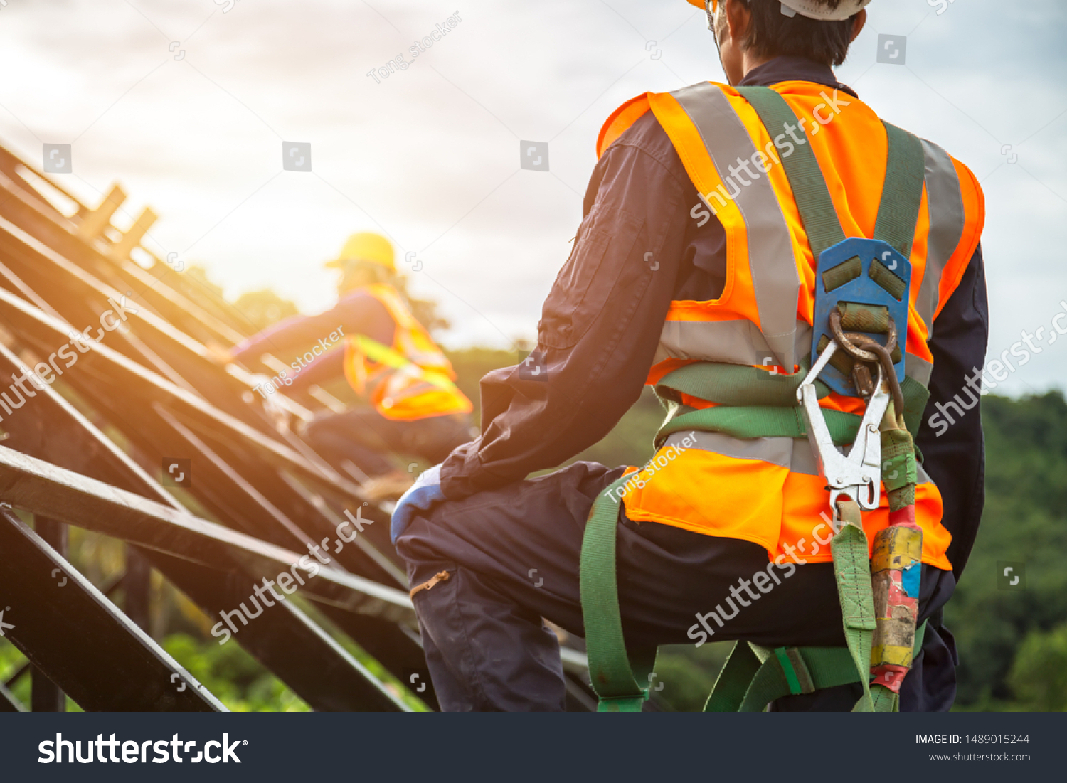 [safety body construction] Working at height equipment. Fall arrestor device for worker with hooks for safety body harness on selective focus. Worker as in construction background. #1489015244