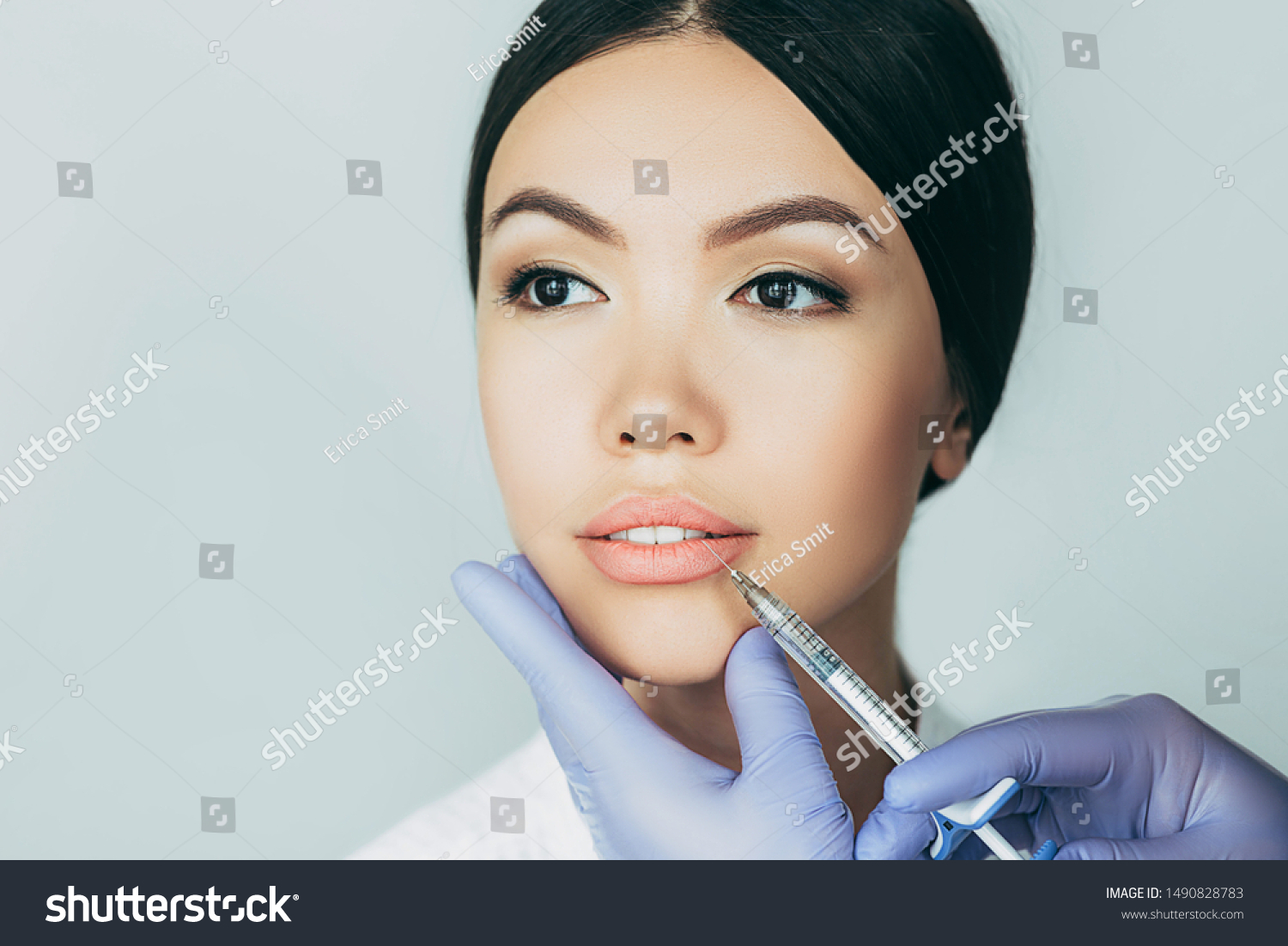 asian woman plumper lips, getting bigger lips. prick of a syringe for the lips. injections for bigger volume #1490828783