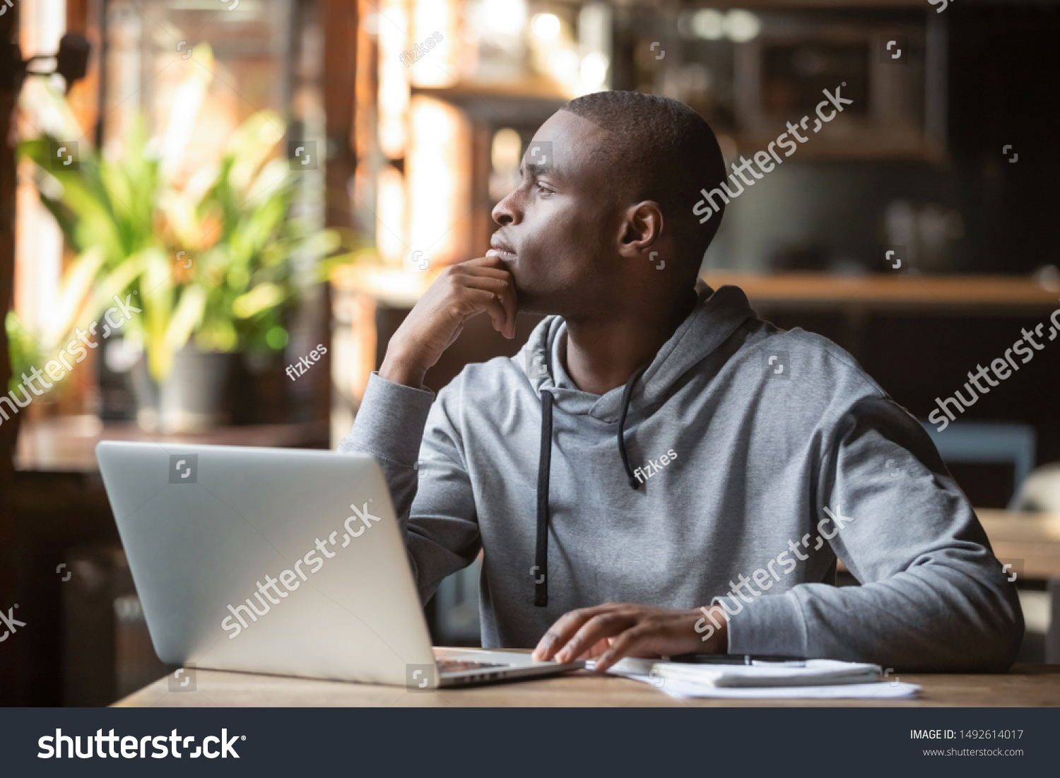 Thoughtful african american businessman lost in thoughts search for inspiration sit at cafe table using laptop, dreamy pensive contemplative black student looking away thinking of new creative ideas #1492614017