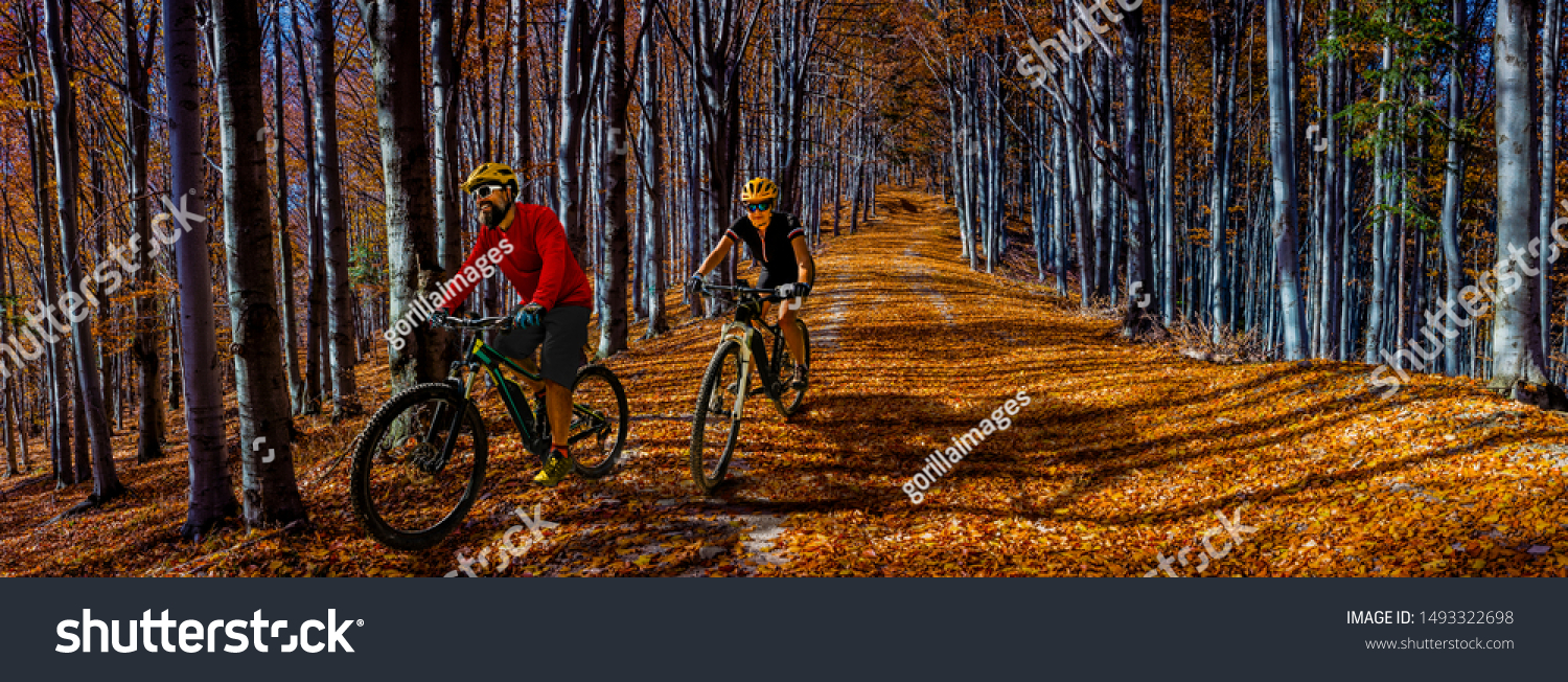 Cycling, mountain biker couple on cycle trail in autumn forest. Mountain biking in autumn landscape forest. Man and woman cycling MTB flow uphill trail. #1493322698