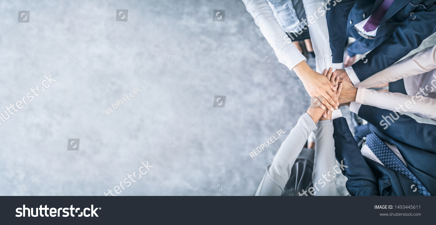 Close up top view of young business people putting their hands together. Stack of hands. Unity and teamwork concept. #1493445611
