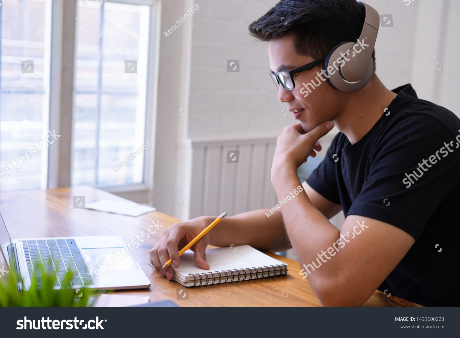 Cropped shot of asian university student using a laptop and wearing headphones. Learning,technology and leisure concept #1493600228