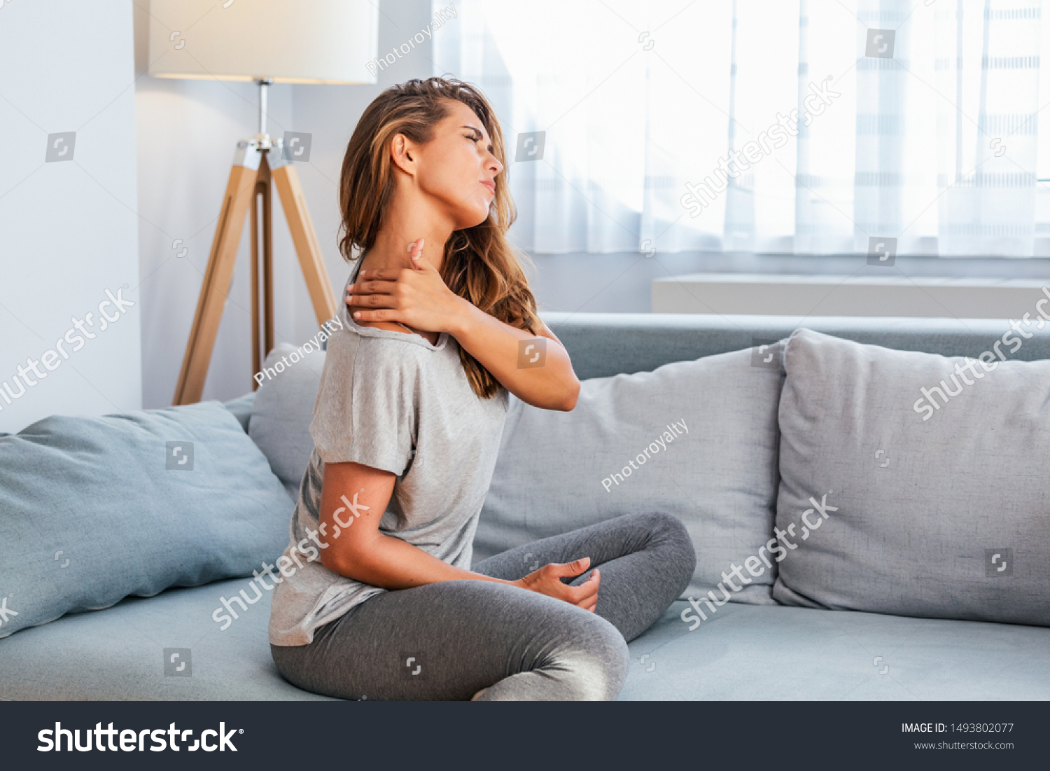 Pain in the shoulder. Upper arm pain, People with body-muscles problem, Healthcare And Medicine concept. Attractive woman sitting on the bed and holding painful shoulder with another hand. #1493802077