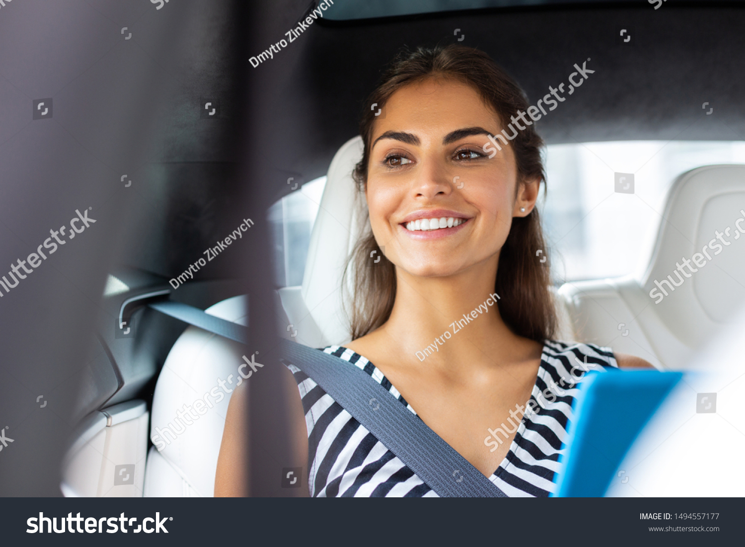 Beaming businesswoman. Beaming businesswoman holding tablet smiling while sitting in car #1494557177