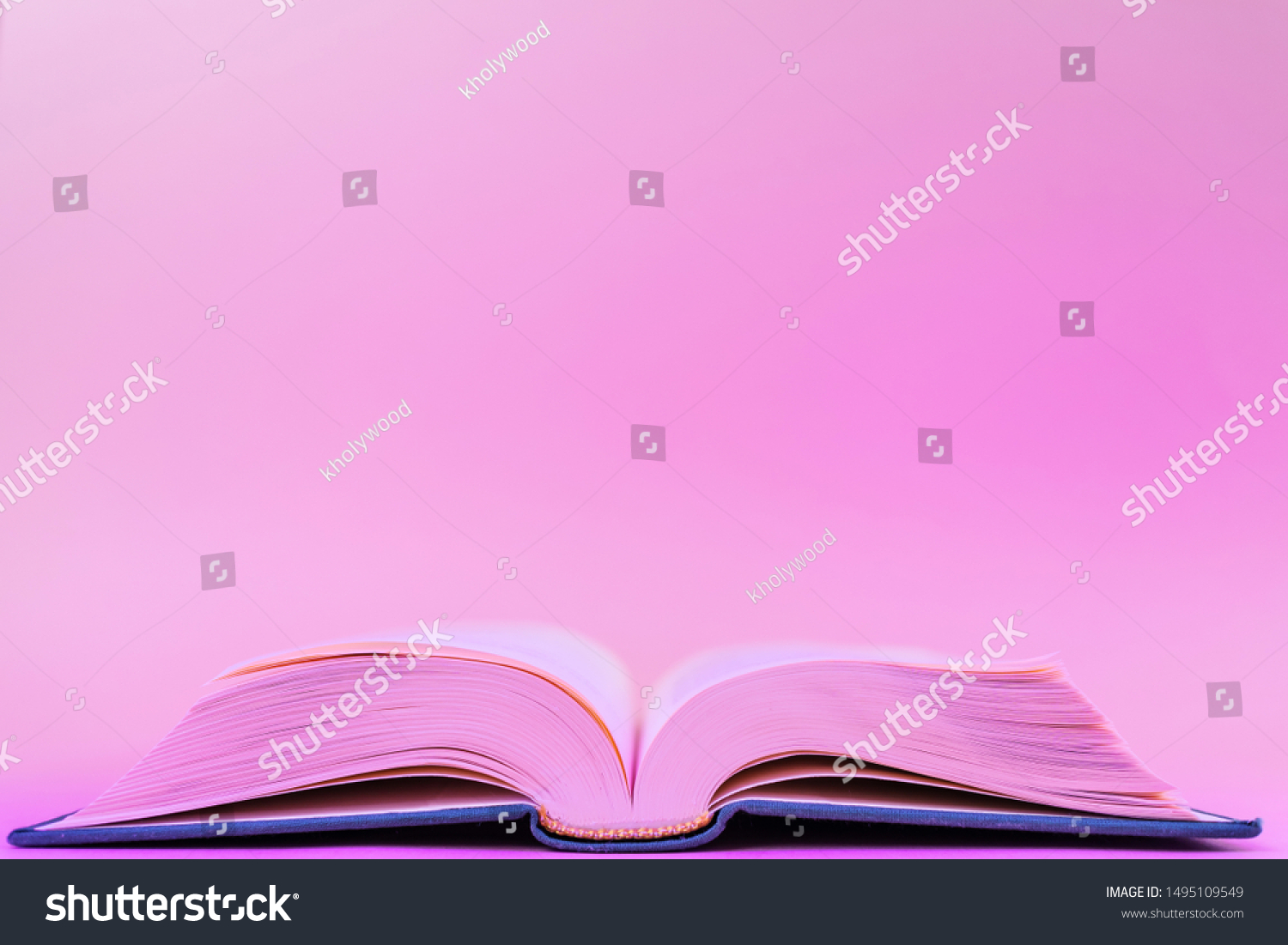 Close-up book on a pastel pink background in a trendy neon color light. The concept of reading, book novelties, book business, literature. Minimalism, place for text. #1495109549