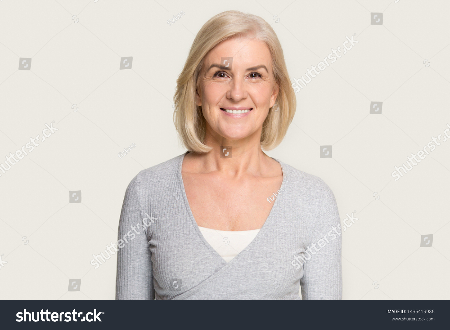 Headshot picture of happy Caucasian senior woman stand isolated on grey studio background look at camera, portrait of smiling aged female with gray hair stand posing, elderly help assistance concept #1495419986