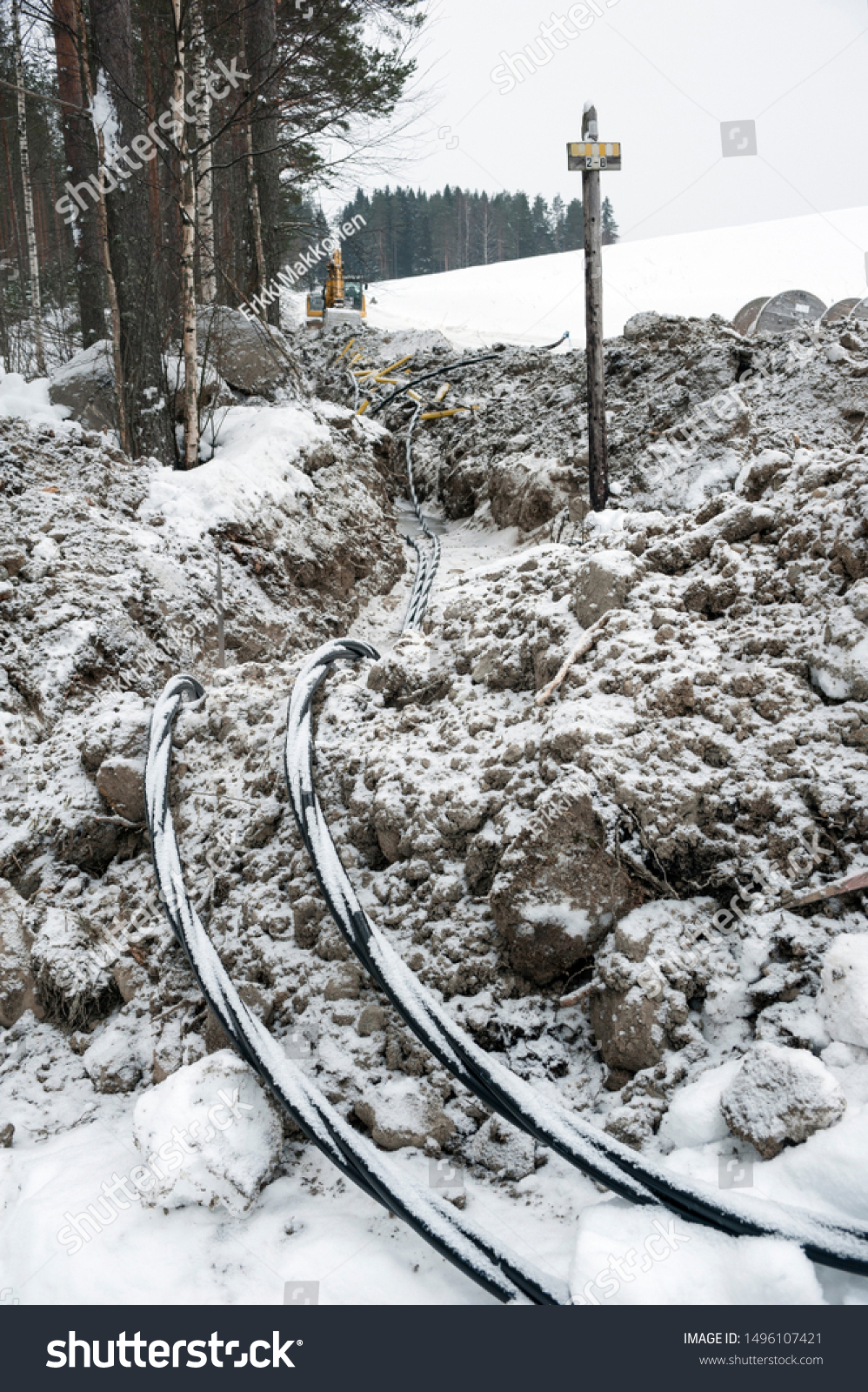 Laying a fiber optic and electricity cables in the frozen ground, buried cables for fast internet in rural region - underground cabling in Finland #1496107421