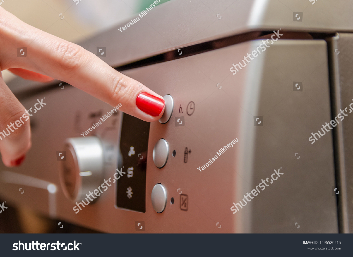 Female hand with red nail polish presses the button to adjust the time in the dishwasher #1496520515