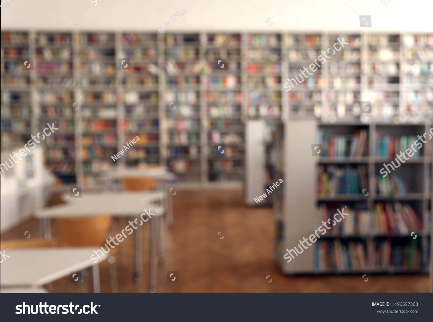 Blurred view of library interior with bookcases and tables #1496597363