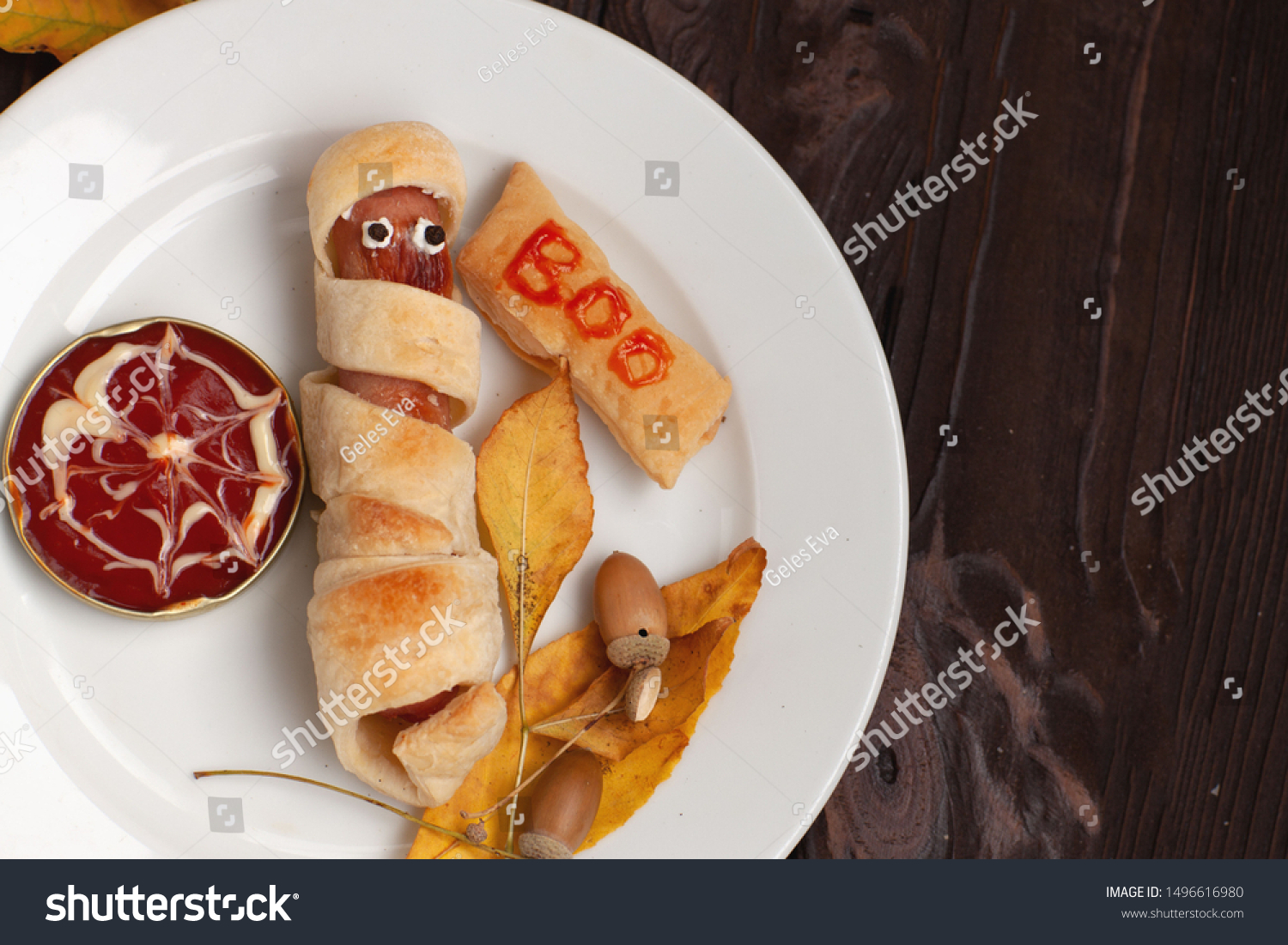 
Mummy sausage in pastry scary Halloween food holiday with eyes on a white plate and vintage wooden brown background #1496616980