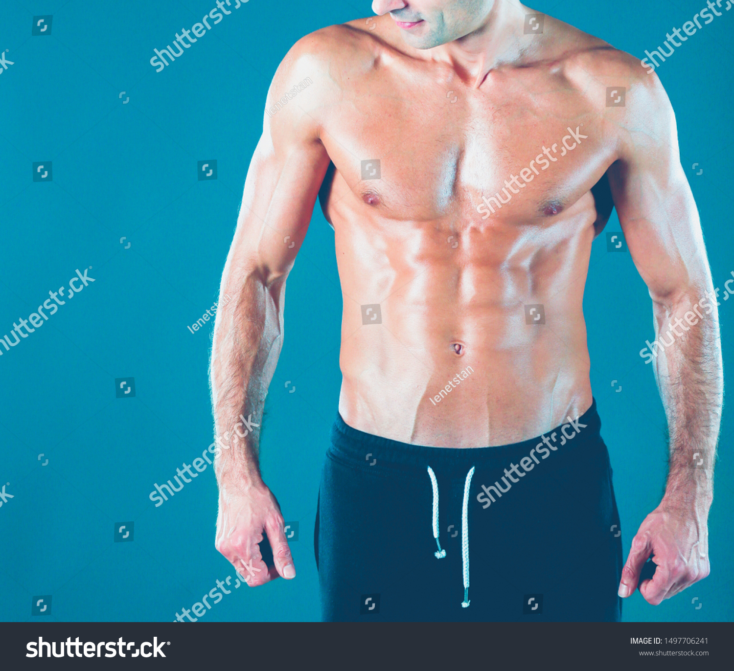 muscular man. Muscular man on a grey background showing muscles. Fitness instructor. Fitness professional. Workout. Men's fitness. #1497706241