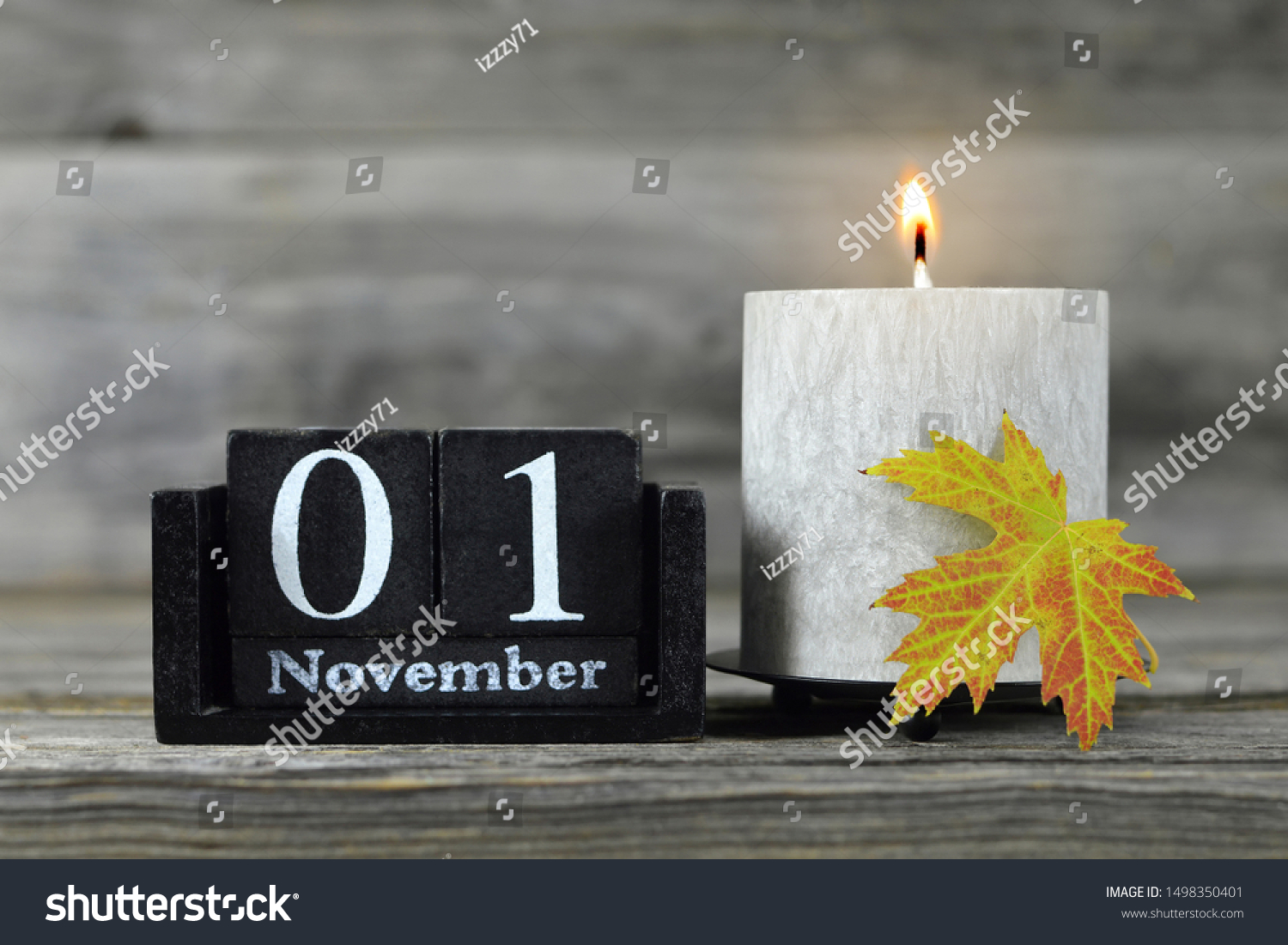 All Saints Day. Burning candle, wooden calendar and yellow autumn leaf #1498350401