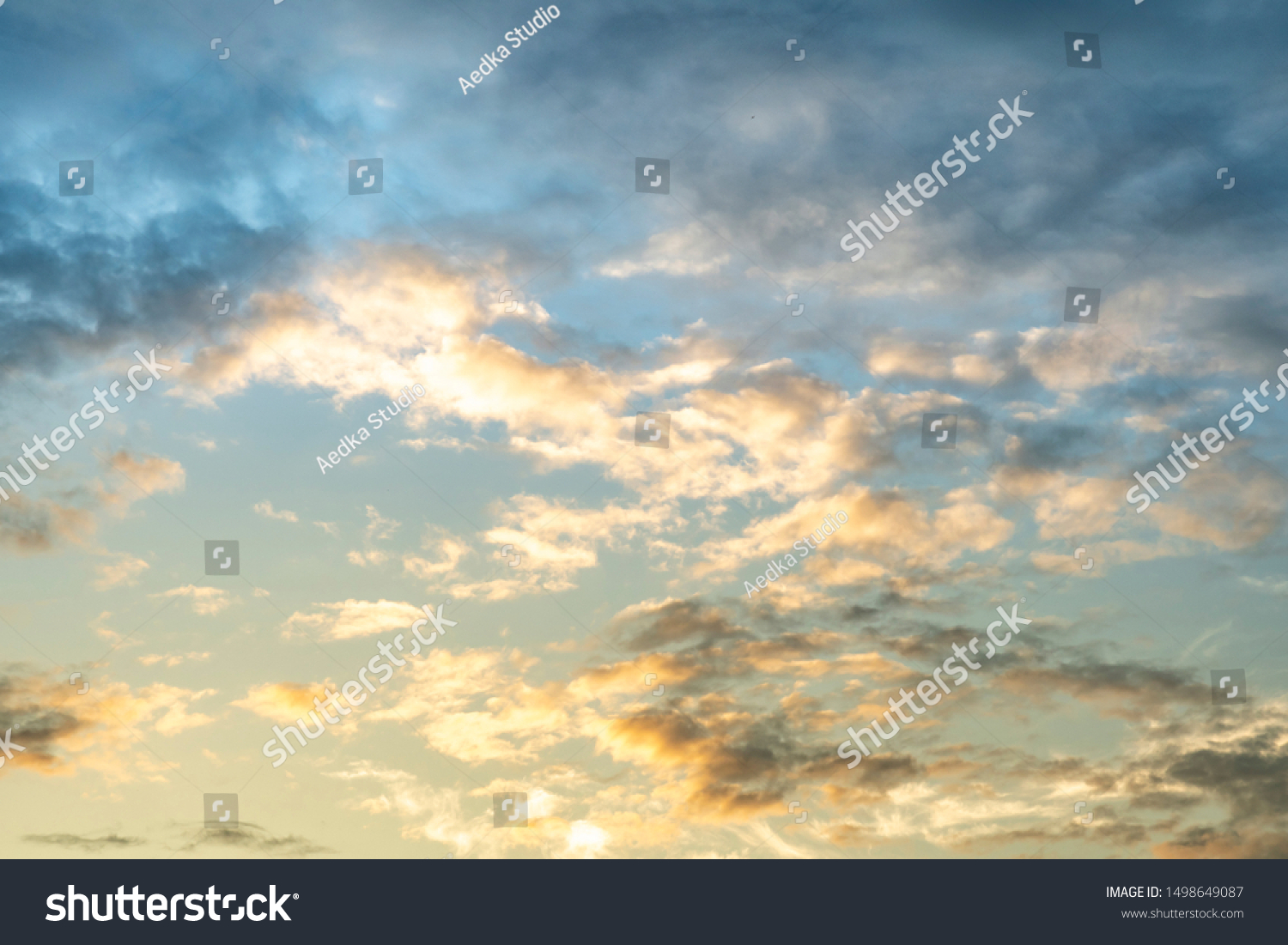 Colorful cloudy sky after rain, Beautiful evening skyscape. Sun's rays shine through hole in black clouds after rain. Sky, Golden sky. Natural background. Inspirational concept. #1498649087