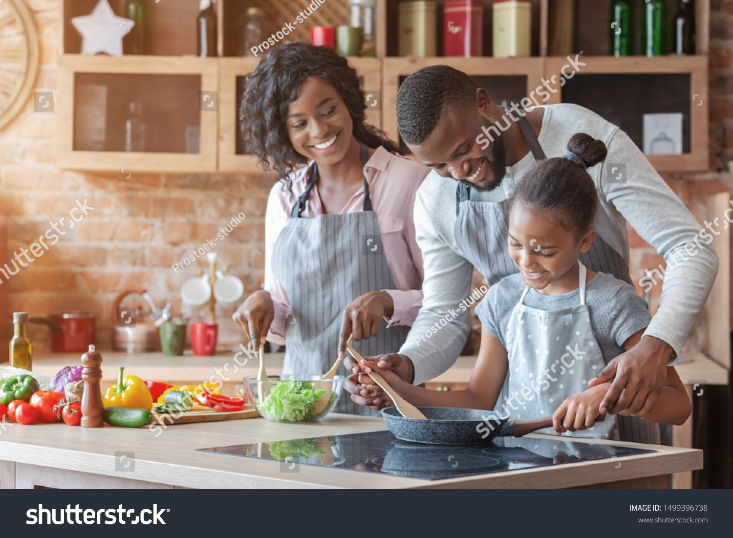 Kind african parents teaching their adorable daughter how to cook healthy food, free space #1499396738