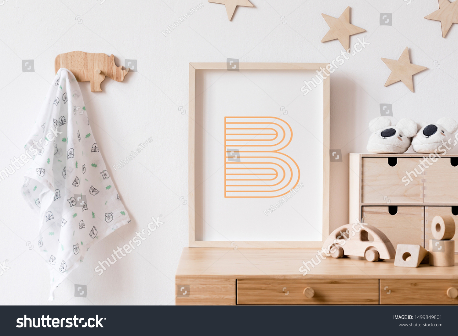 Stylish scandi childroom withwooden mock up photo frame, wooden toys, boxes, blocks and accessories Stars pattern on the background wall. Bright and sunny interior with wooden desk. Home decor. #1499849801