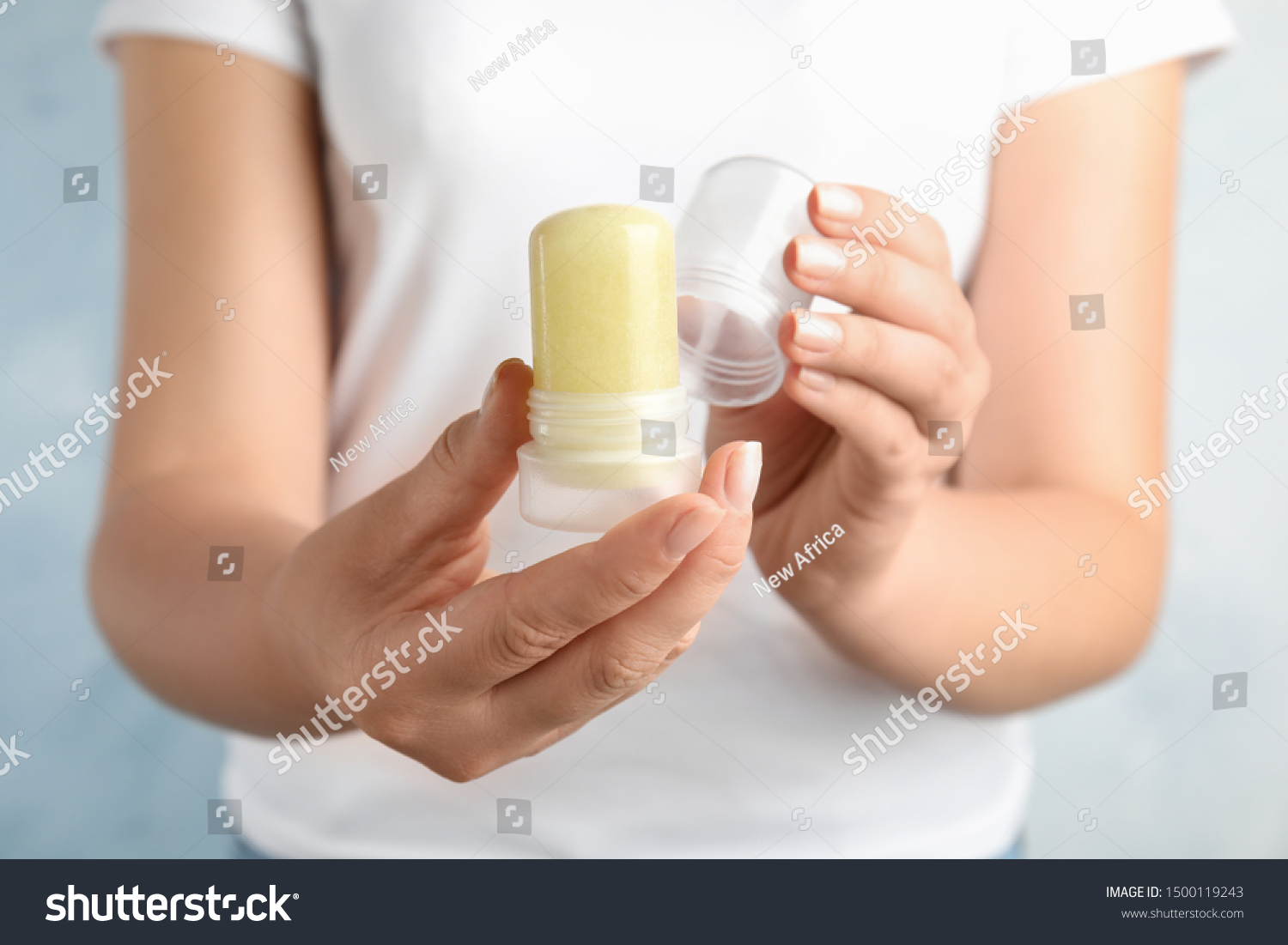 Young woman holding natural crystal alum stick deodorant, closeup #1500119243