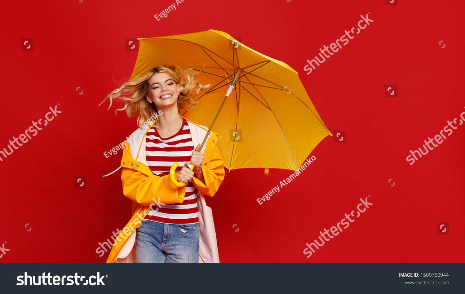 young happy emotional cheerful girl laughing and jumping with yellow umbrella   on colored red background
 #1500750944