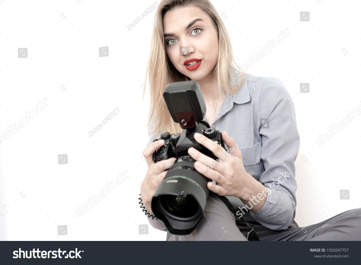 Beautiful girl journalist with a big camera in hands on a white background #1502047757