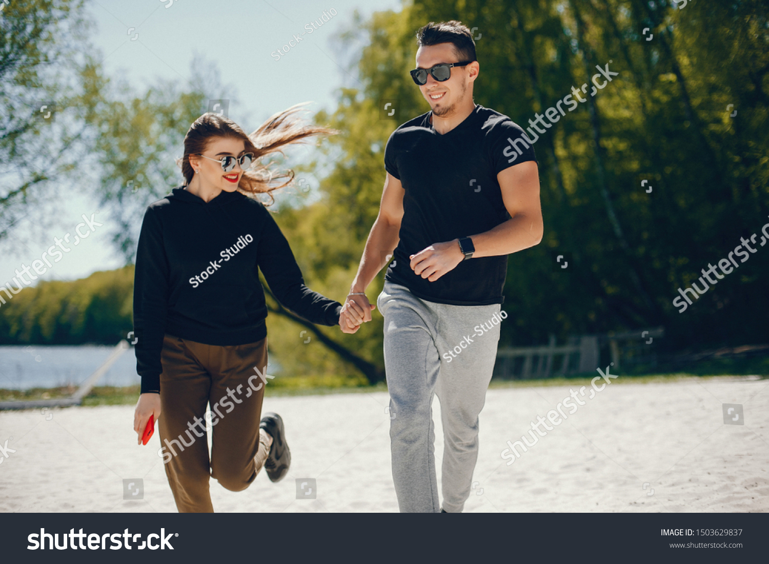 A stylish and bright love couple walks on the sunny beach #1503629837