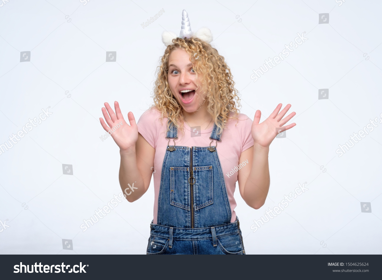 Cheerful excited curly woman wearing funny unicorn horn screaming in delight and excitement, getting excellent news. #1504625624